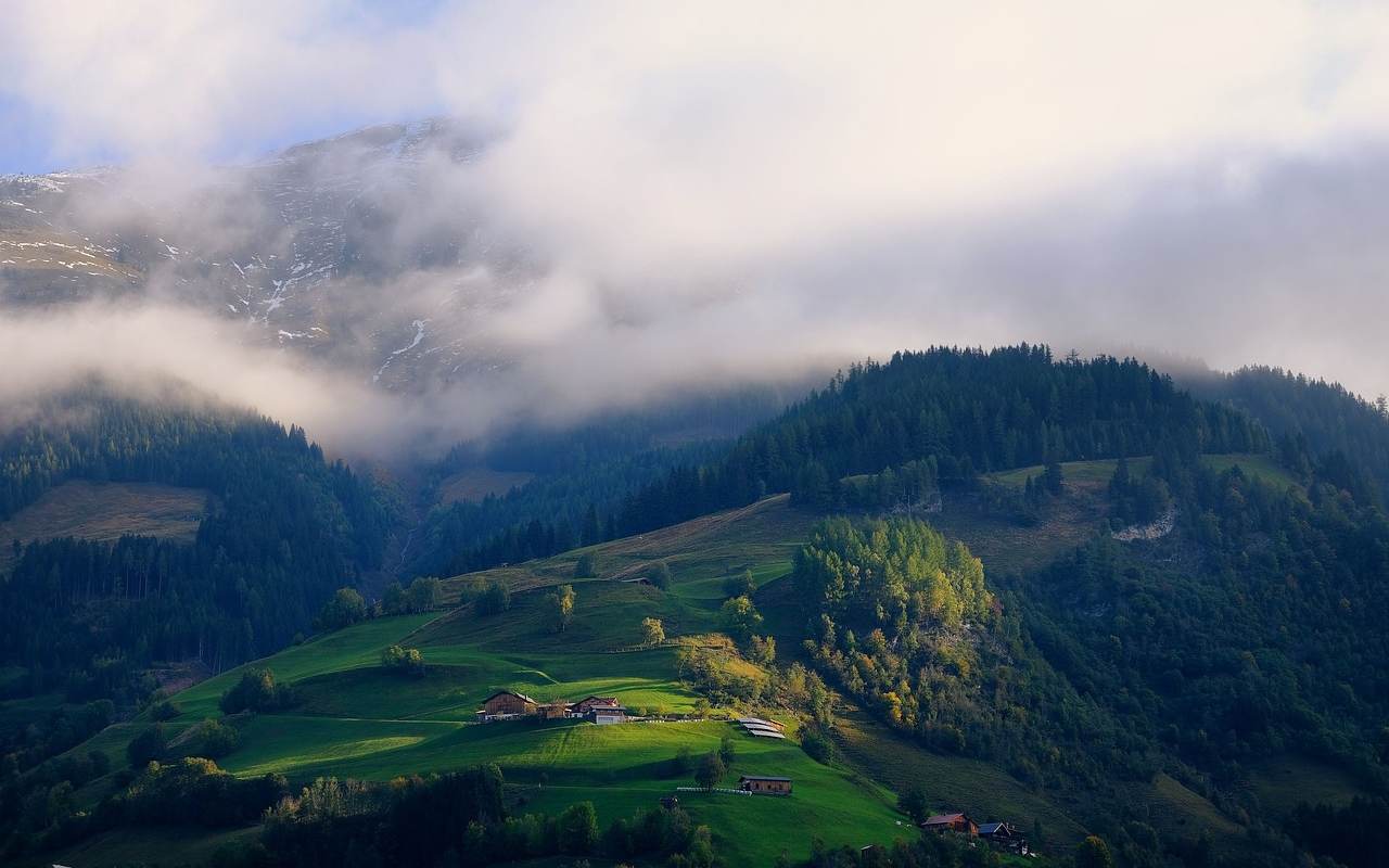 https://pixabay.com/photos/mountains-fog-clouds-nature-6721870/ Šumovito brdo prekriveno maglom sa kućama na proplancima